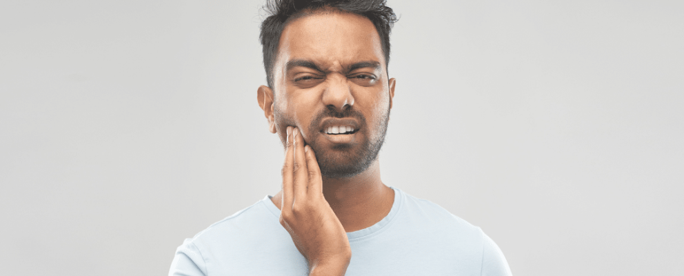 guy holding jaw with jaw pain