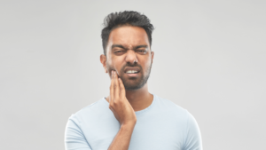 guy holding jaw with jaw pain