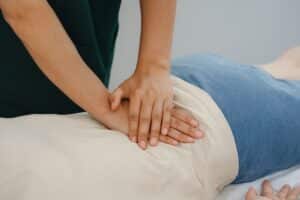 chiropractor pressing down on patient lower back