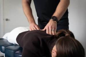 chiropractor pressing top of back