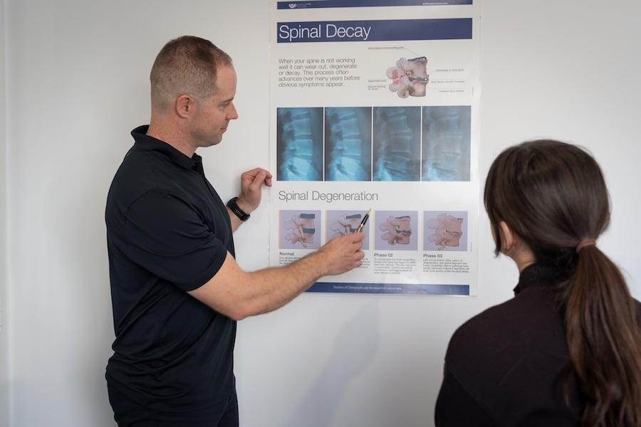 chiropractor pointing at back conditions page